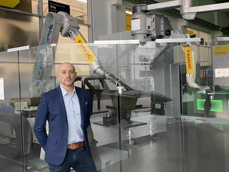 Robin Kaufmann vor einem Fanuc-Roboter